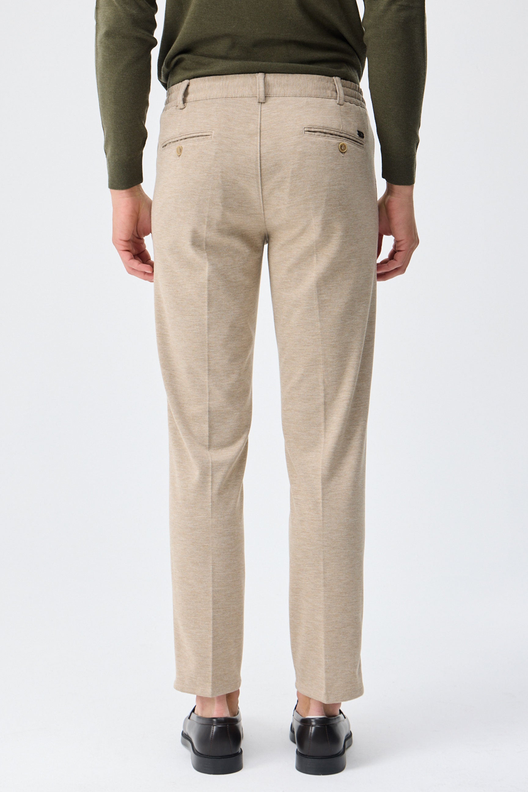 Traje elegante informal de hombre en jersey suave color beige: chaqueta y pantalón.