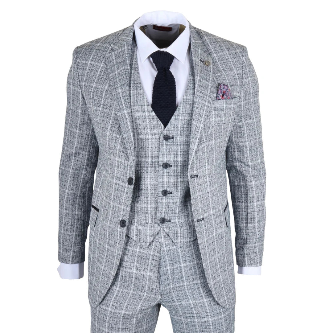 Traje gris a cuadros con camisa blanca, corbata negra y pañuelo de bolsillo sobre fondo blanco.