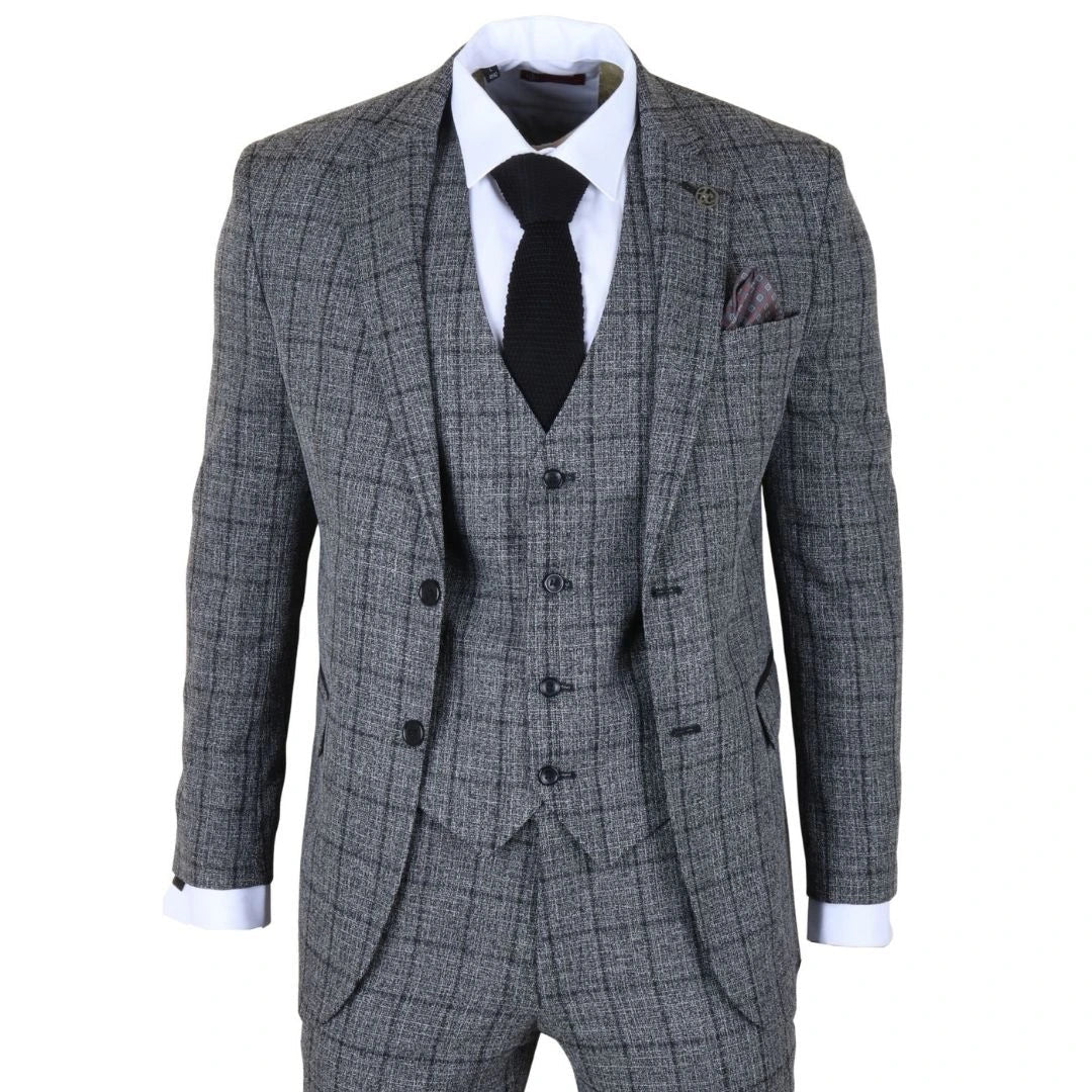 Traje gris a cuadros con camisa blanca, corbata negra y pañuelo de bolsillo sobre fondo blanco.