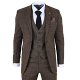 Traje a cuadros marrón con camisa blanca y corbata negra sobre fondo blanco.