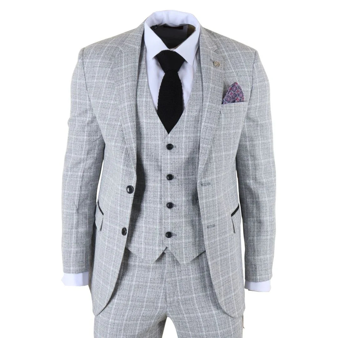 Traje gris a cuadros con corbata negra y pañuelo de bolsillo morado sobre fondo blanco.
