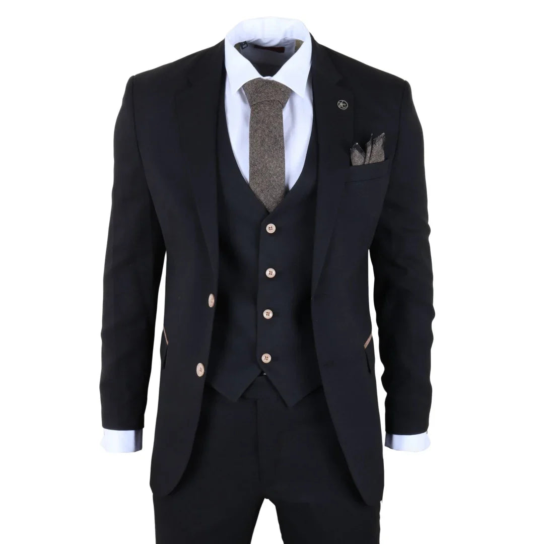 Traje de tres piezas negro con corbata y pañuelo de bolsillo sobre fondo blanco.