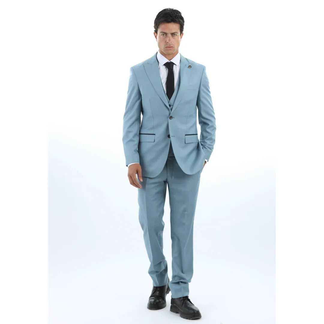Hombre con traje azul claro, camisa blanca y corbata negra sobre fondo blanco.