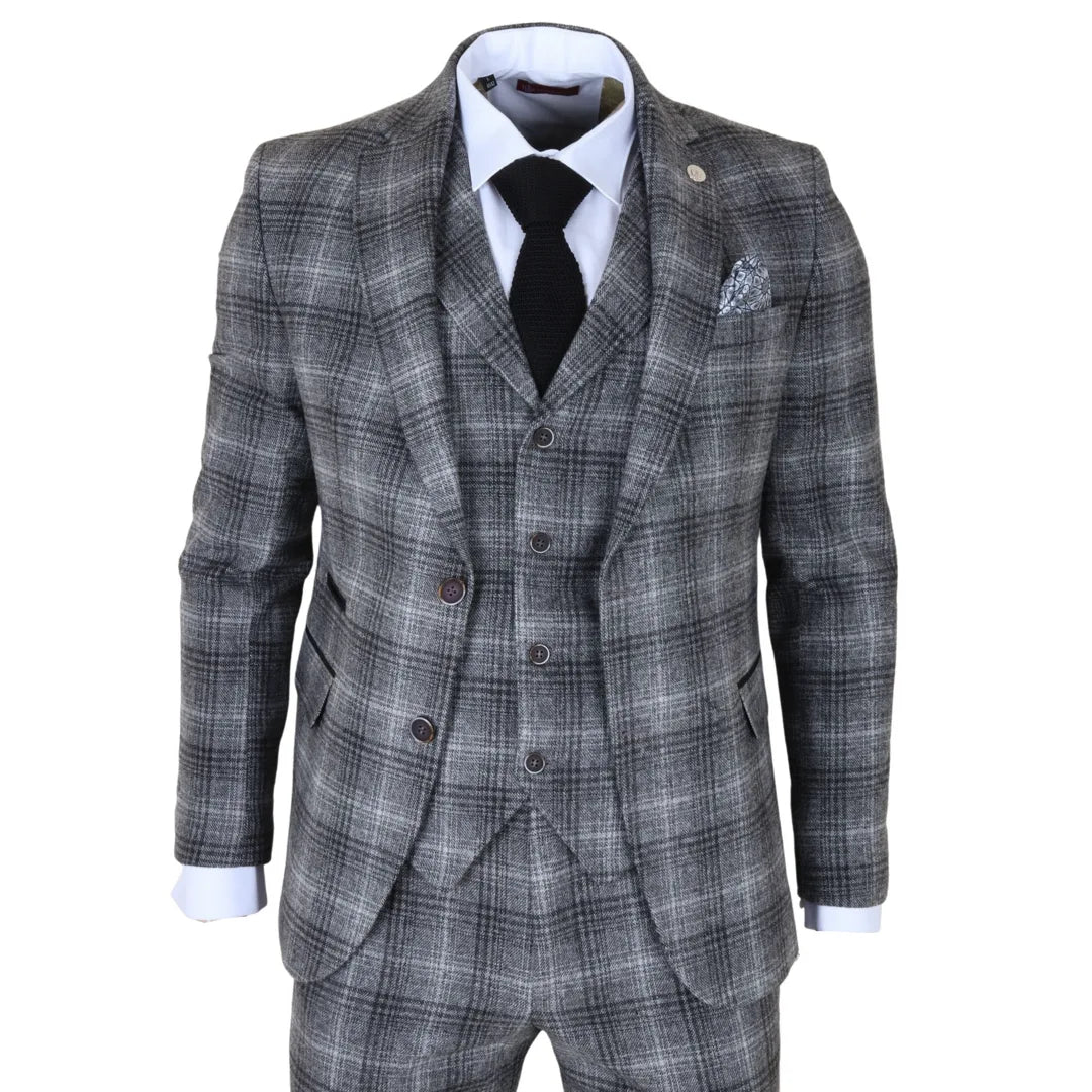 Traje gris a cuadros con camisa blanca, corbata negra y pañuelo de bolsillo sobre fondo blanco.