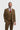Hombre con traje marrón, corbata roja y pañuelo de bolsillo sobre fondo blanco.