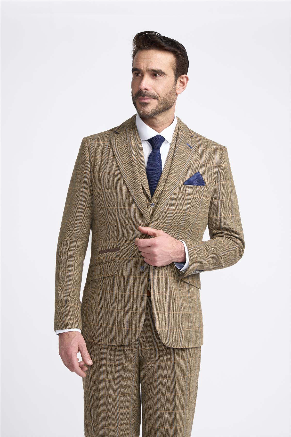 Hombre con traje a cuadros marrón y corbata azul sobre fondo blanco