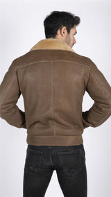 Chaqueta de aviador para hombre de piel de oveja auténtica con cremallera cruzada y pelo color marrón camel.