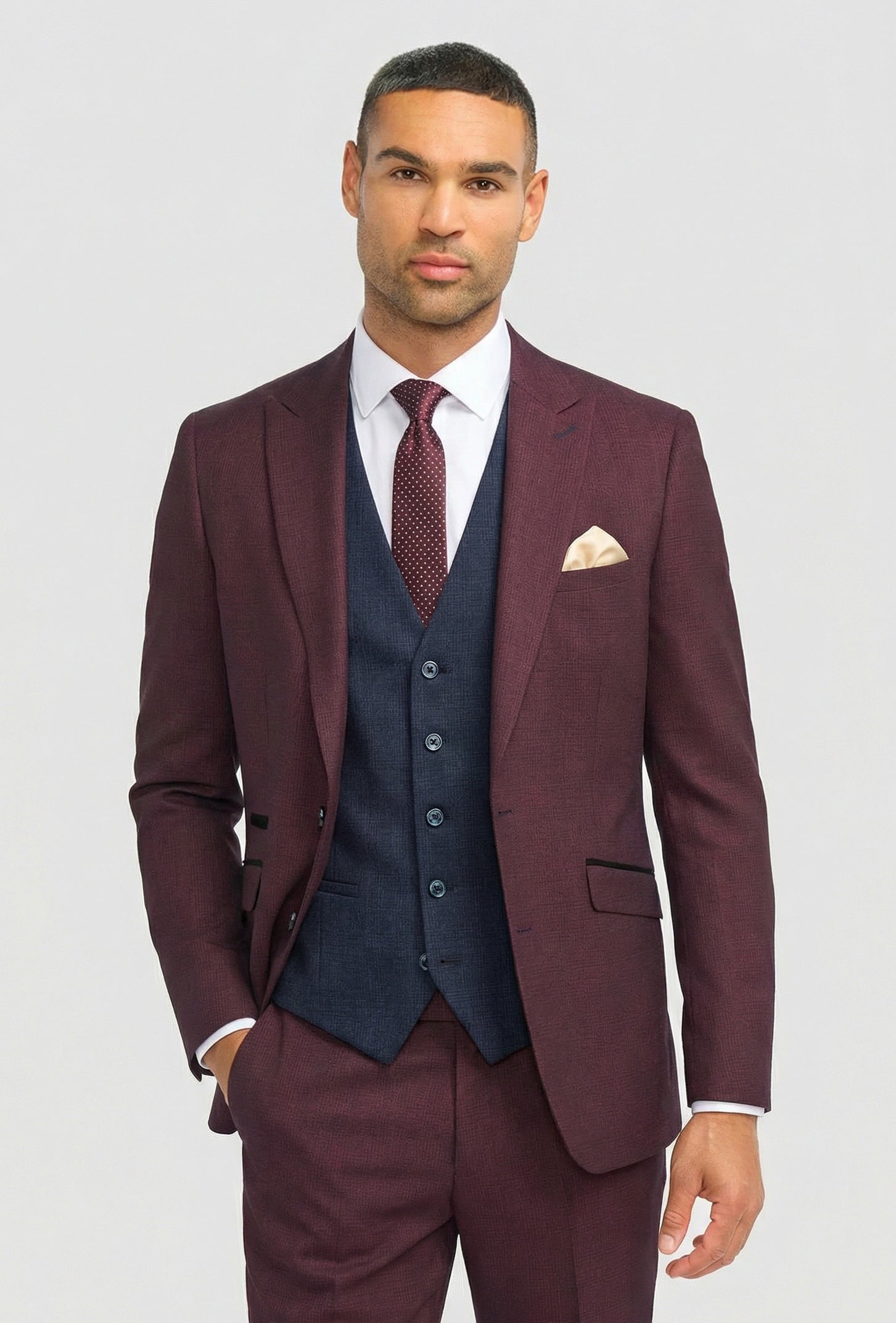 Traje de hombre a cuadros color burdeos con chaleco azul marino en contraste.