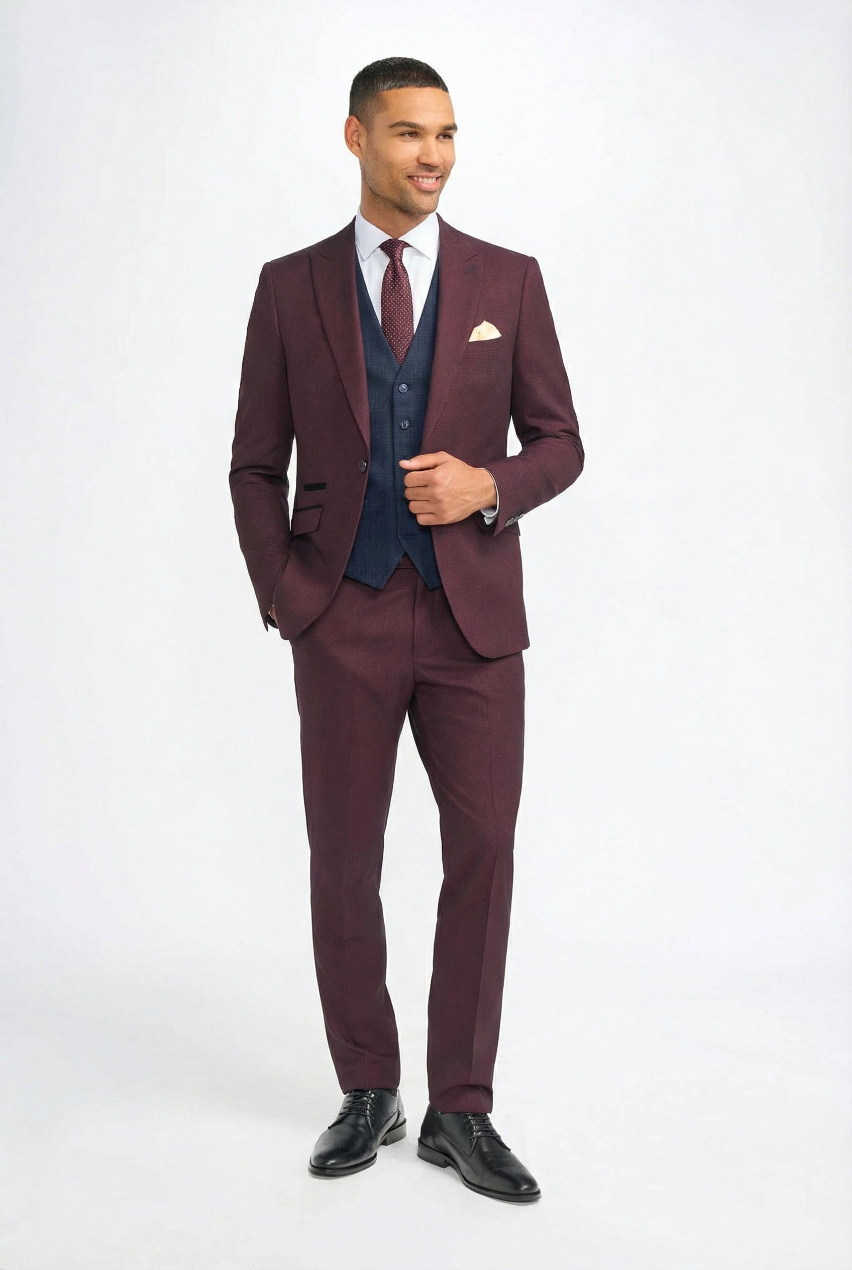 Traje de hombre a cuadros color burdeos con chaleco azul marino en contraste.