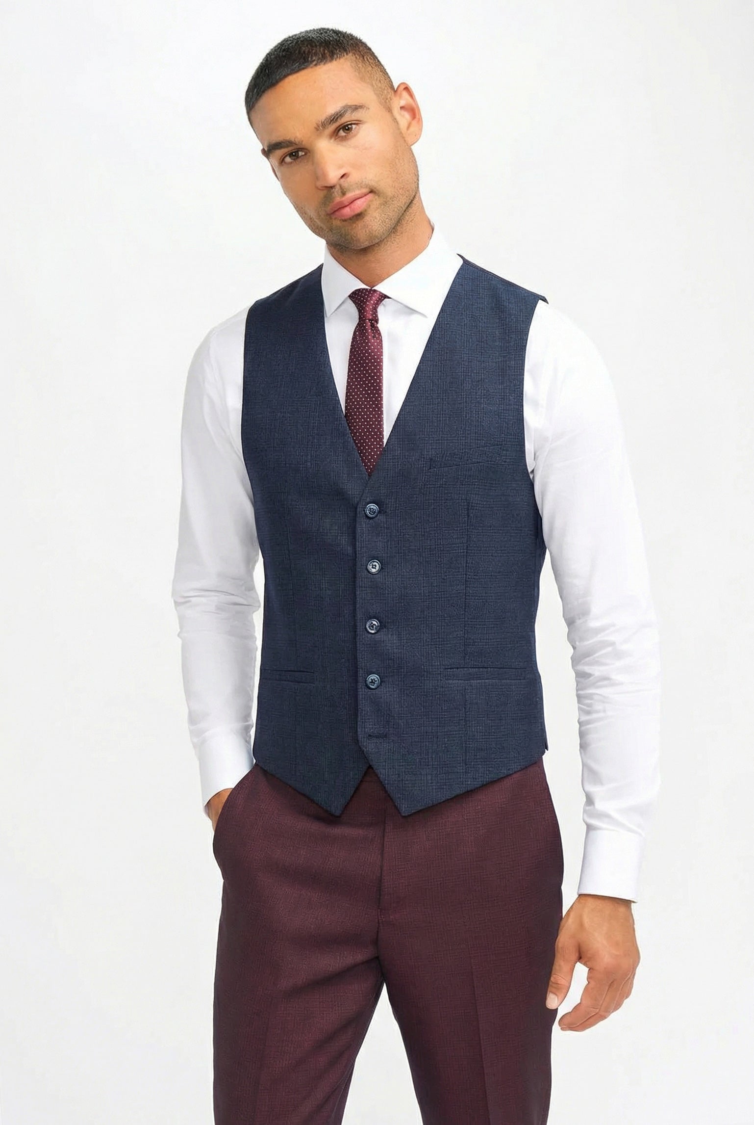 Traje de hombre a cuadros color burdeos con chaleco azul marino en contraste.