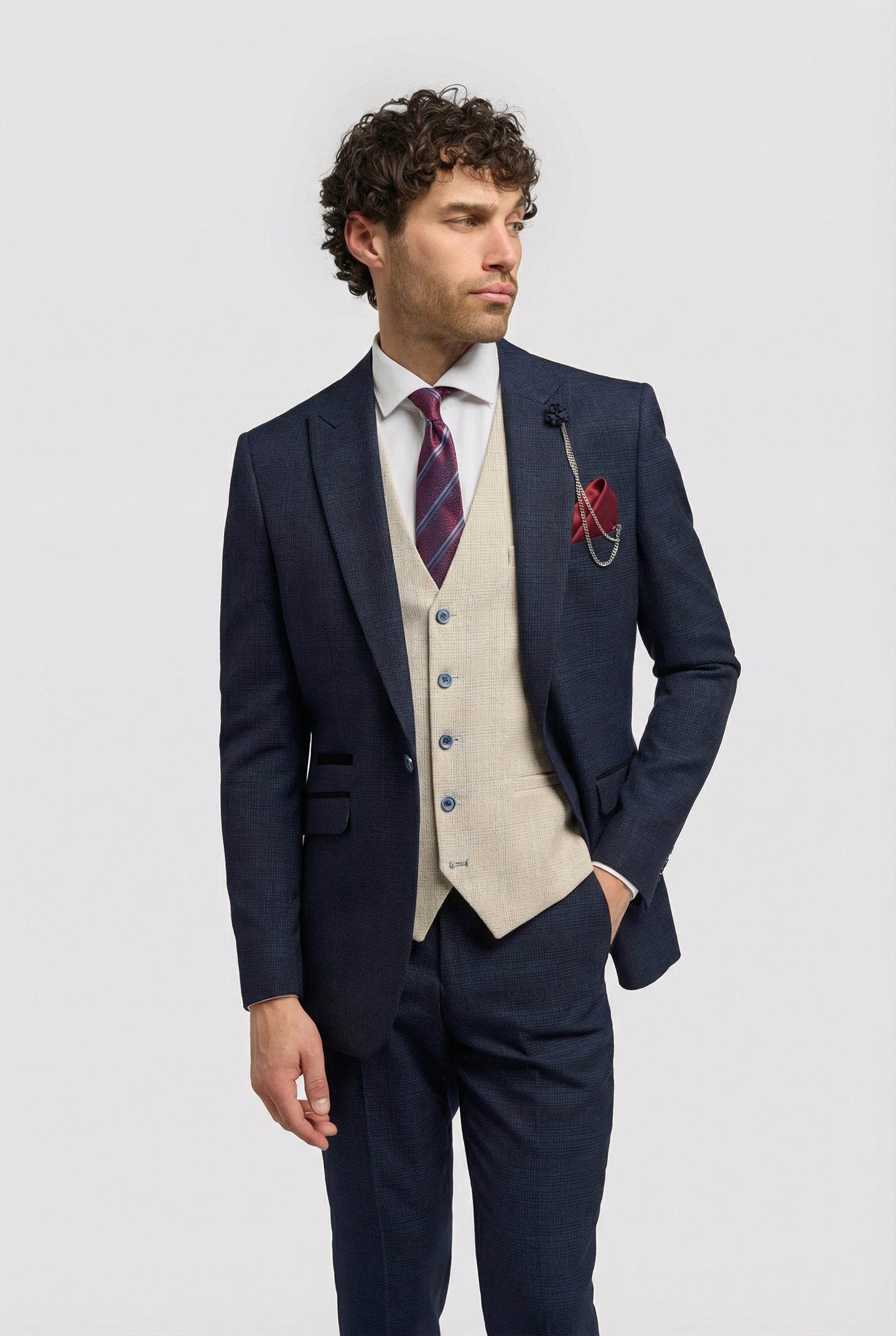 Traje de tres piezas para hombre, azul marino a cuadros, con chaleco color crema en contraste.