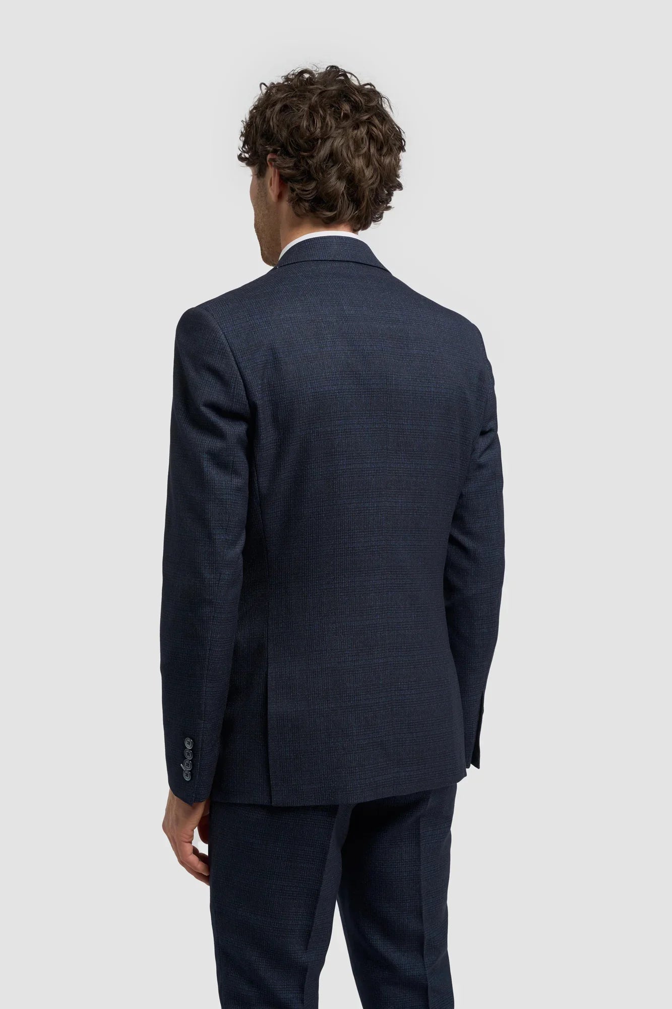 Traje de tres piezas para hombre, azul marino a cuadros, con chaleco color crema en contraste.