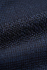 Traje de tres piezas para hombre, azul marino a cuadros, con chaleco color crema en contraste.