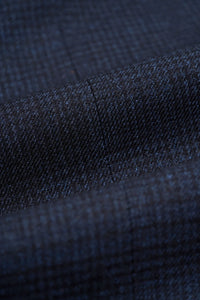 Traje de tres piezas para hombre, azul marino a cuadros, con chaleco color crema en contraste.