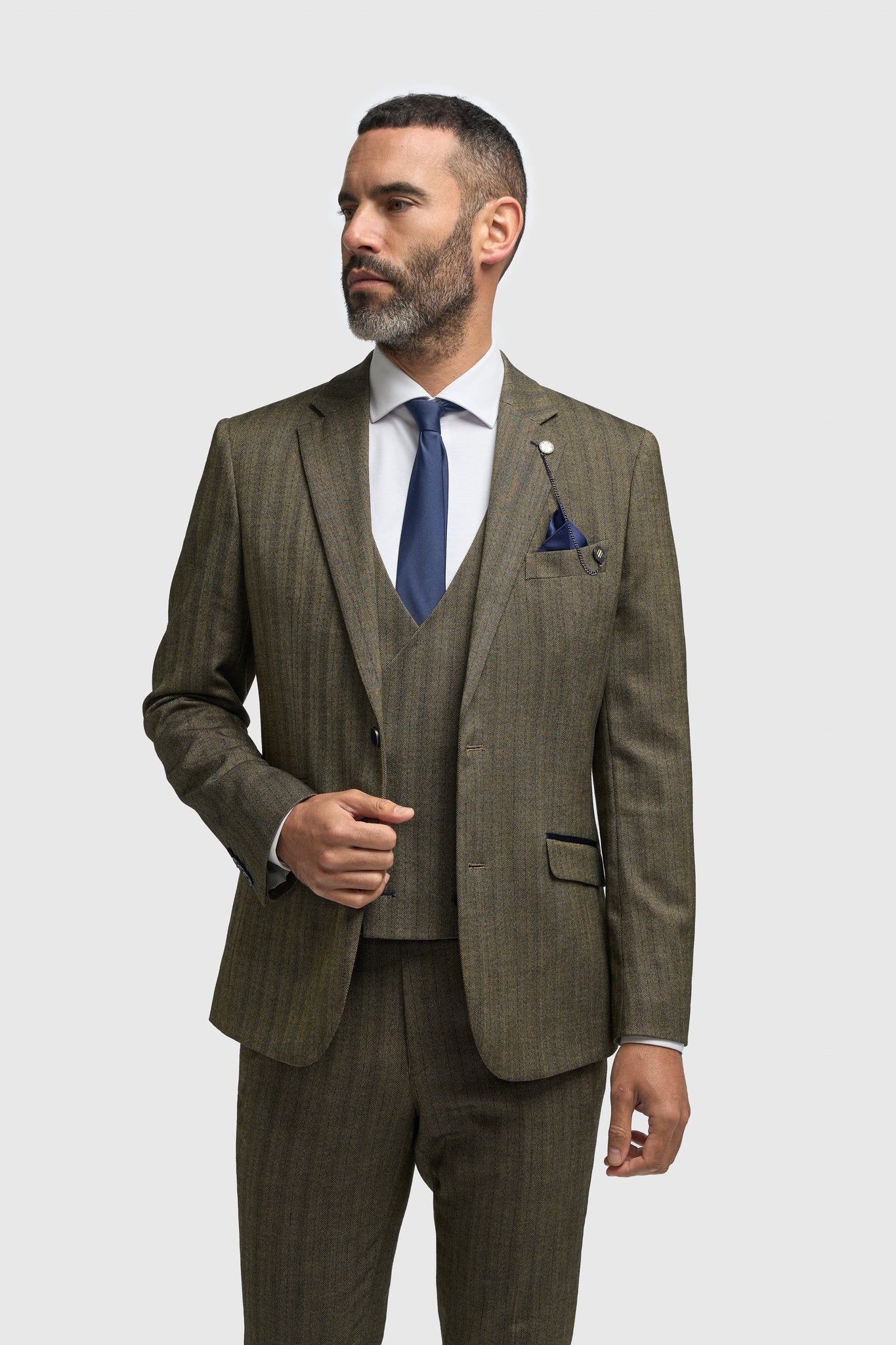 Hombre con traje a cuadros marrón y corbata azul sobre fondo blanco