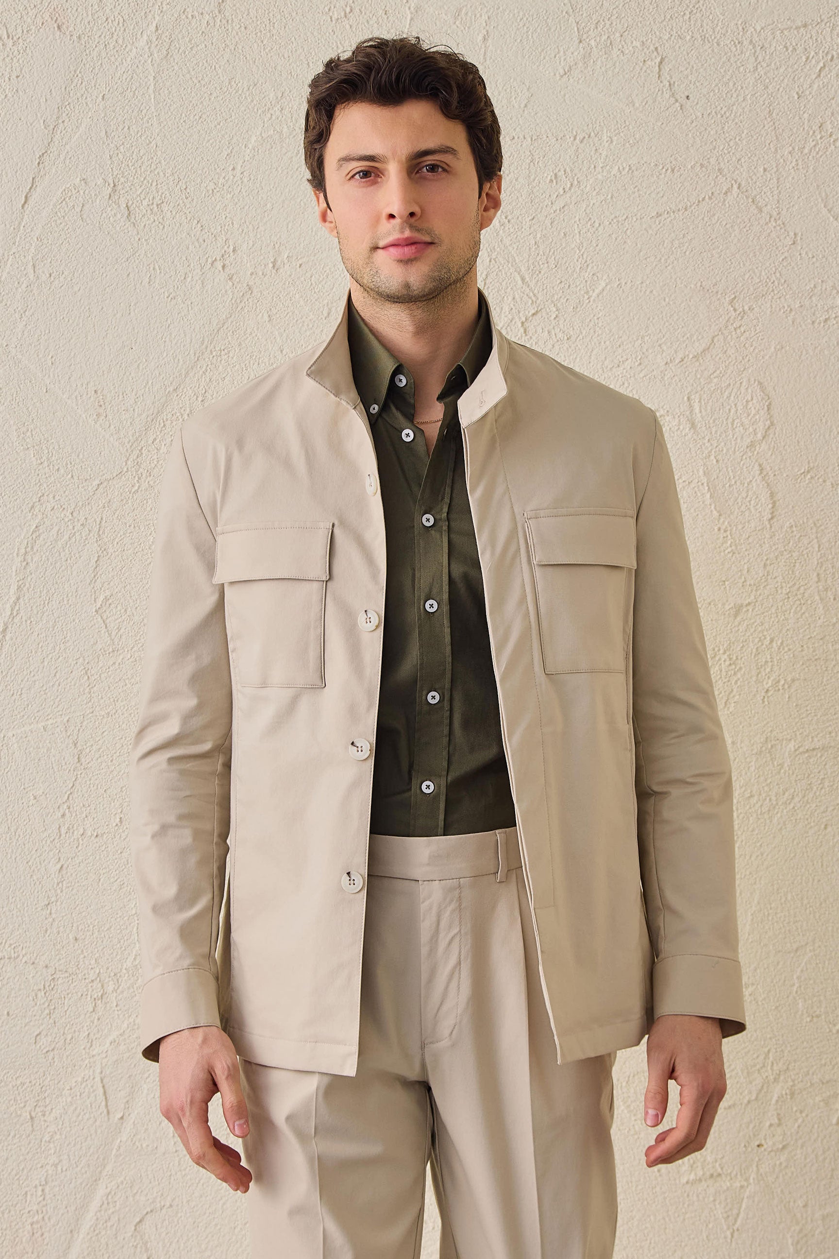 Traje de dos piezas beige elegante e informal para hombre, estilo safari, con cuello alto y tejido elástico.