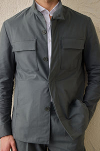 Traje de dos piezas para hombre en color verde salvia, estilo safari, con cuello alto y tejido elástico.