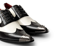 Zapatos de charol para hombre en blanco y negro con puntera metálica.