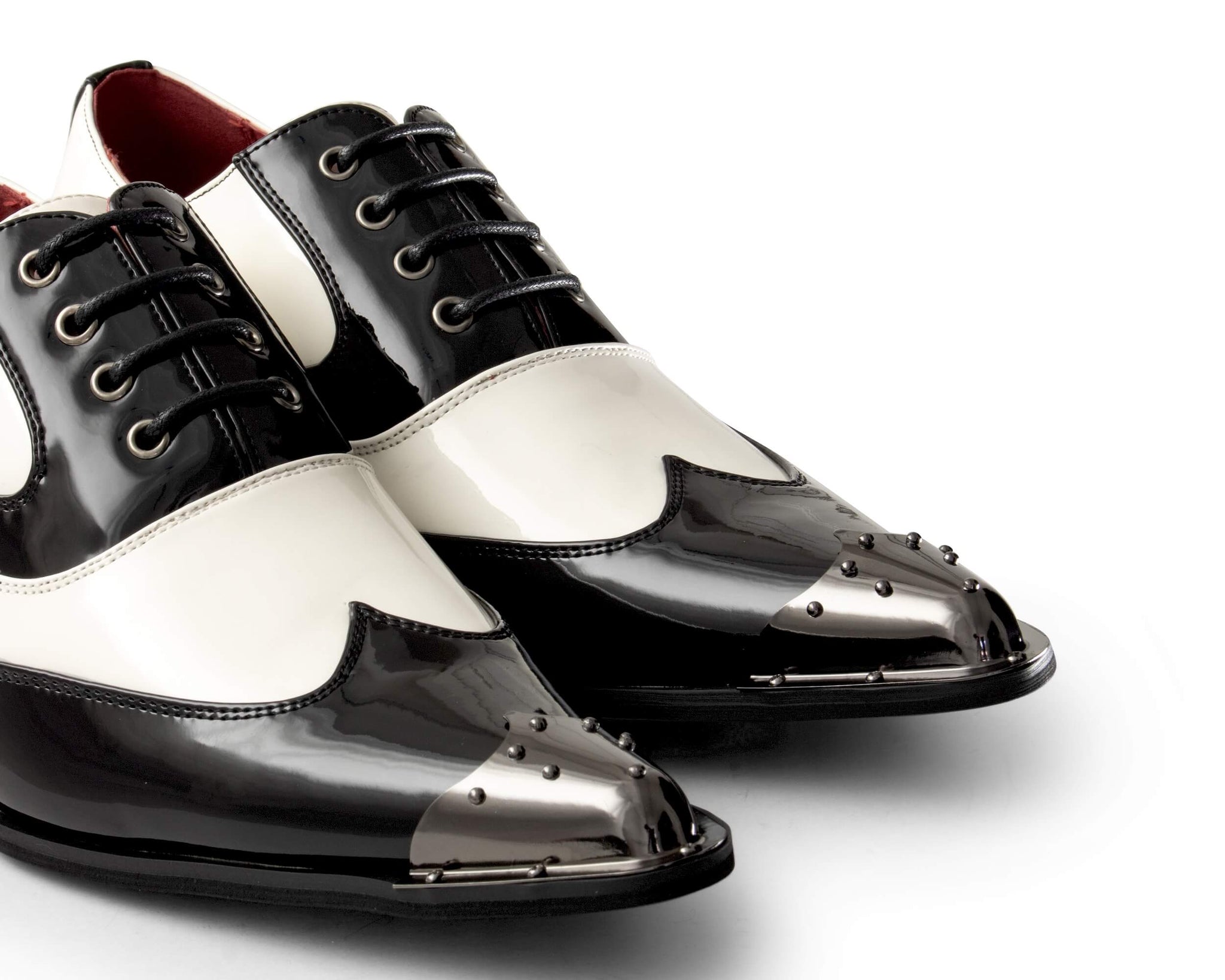 Zapatos de charol para hombre en blanco y negro con puntera metálica.