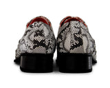 Zapatos de hombre grises con diseño de piel de serpiente y puntera metálica.