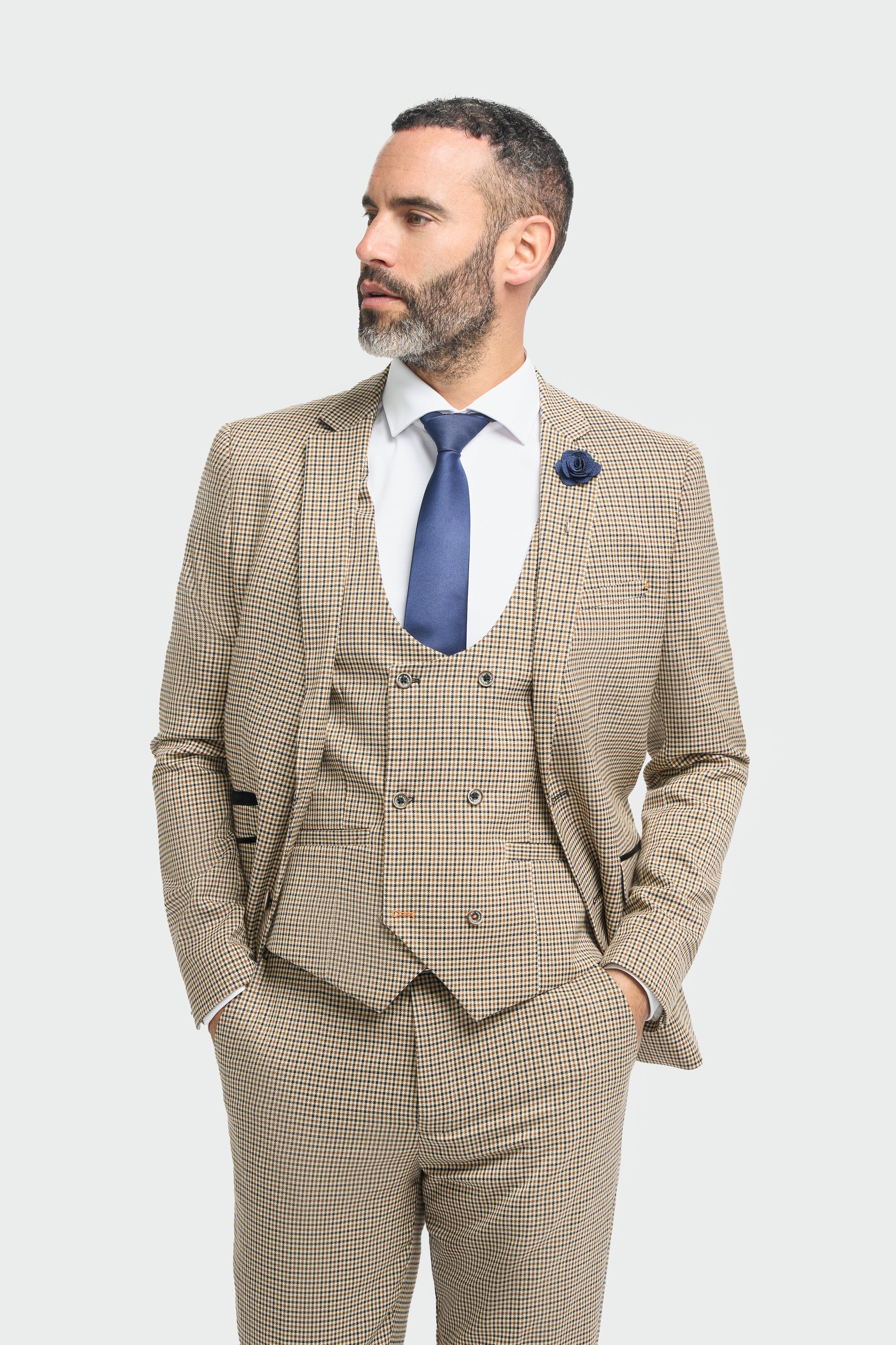 Hombre con traje a cuadros beige y corbata azul sobre fondo blanco