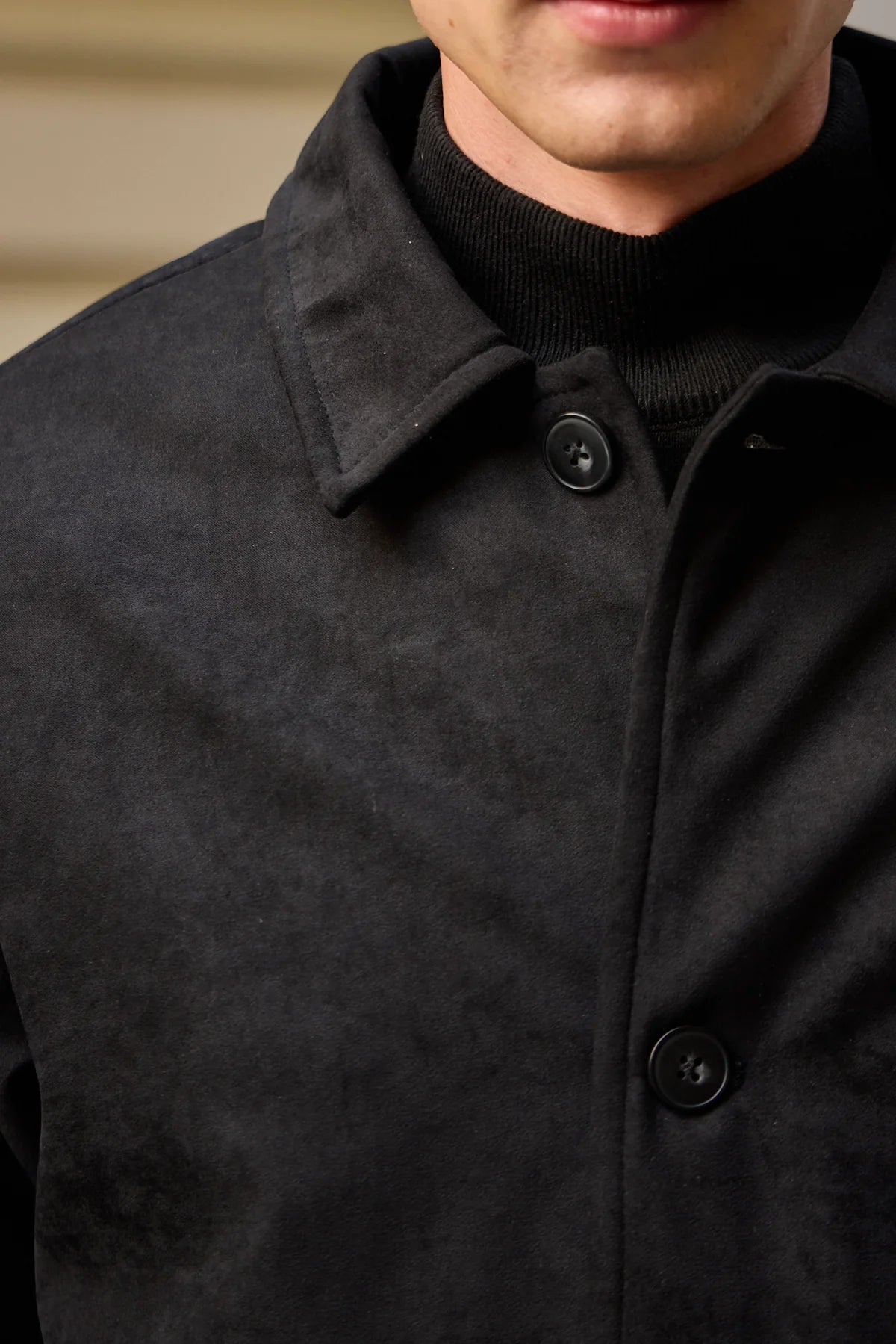 Chaqueta de hombre de ante negro acolchada con forro y cierre de botones.