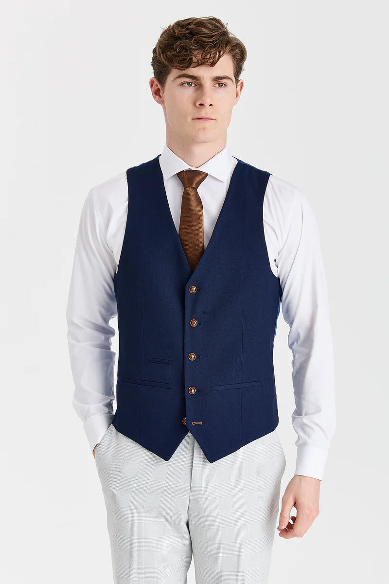 Traje de Mark Stone con chaleco azul marino Mayfair en contraste.