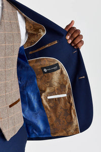 Traje Mayfair azul marino texturizado con chaleco de tweed marrón Harris en contraste.