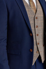 Traje Mayfair azul marino texturizado con chaleco de tweed marrón Harris en contraste.