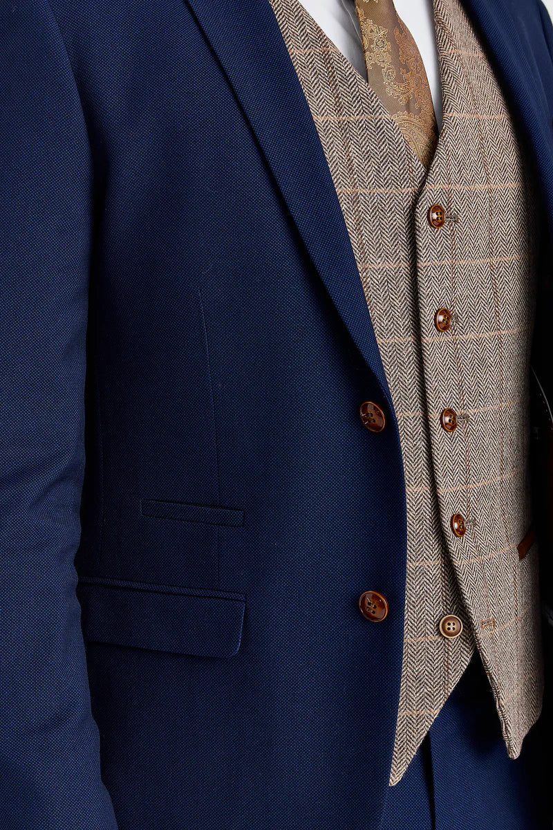 Traje Mayfair azul marino texturizado con chaleco de tweed marrón Harris en contraste.