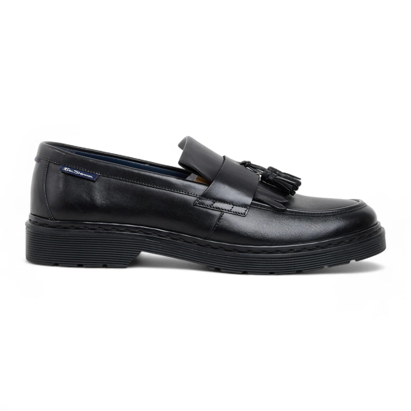 Zapatos mocasines de hombre de cuero negro con suela gruesa y borlas.