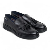 Zapatos mocasines de hombre de cuero negro con suela gruesa y borlas.