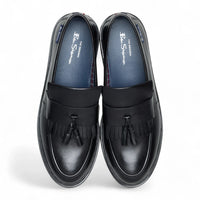 Zapatos mocasines de hombre de cuero negro con suela gruesa y borlas.