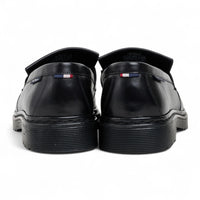 Zapatos mocasines de hombre de cuero negro con suela gruesa y borlas.