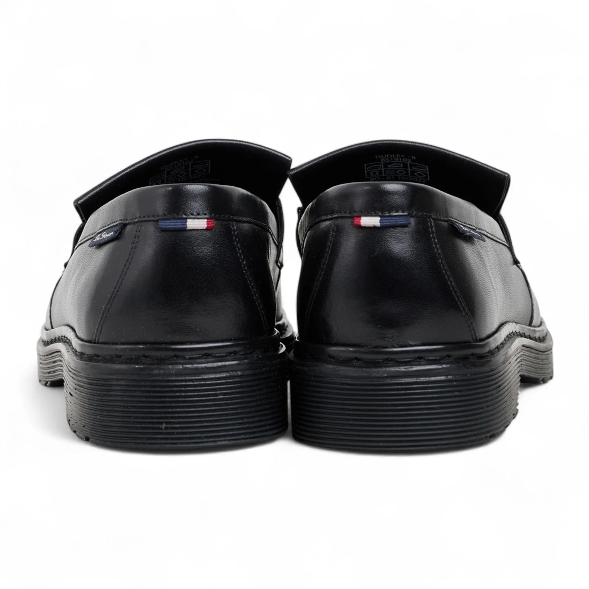Zapatos mocasines de hombre de cuero negro con suela gruesa y borlas.