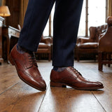 Zapatos de hombre de cuero burdeos, estilo clásico formal, con cordones y diseño brogue.