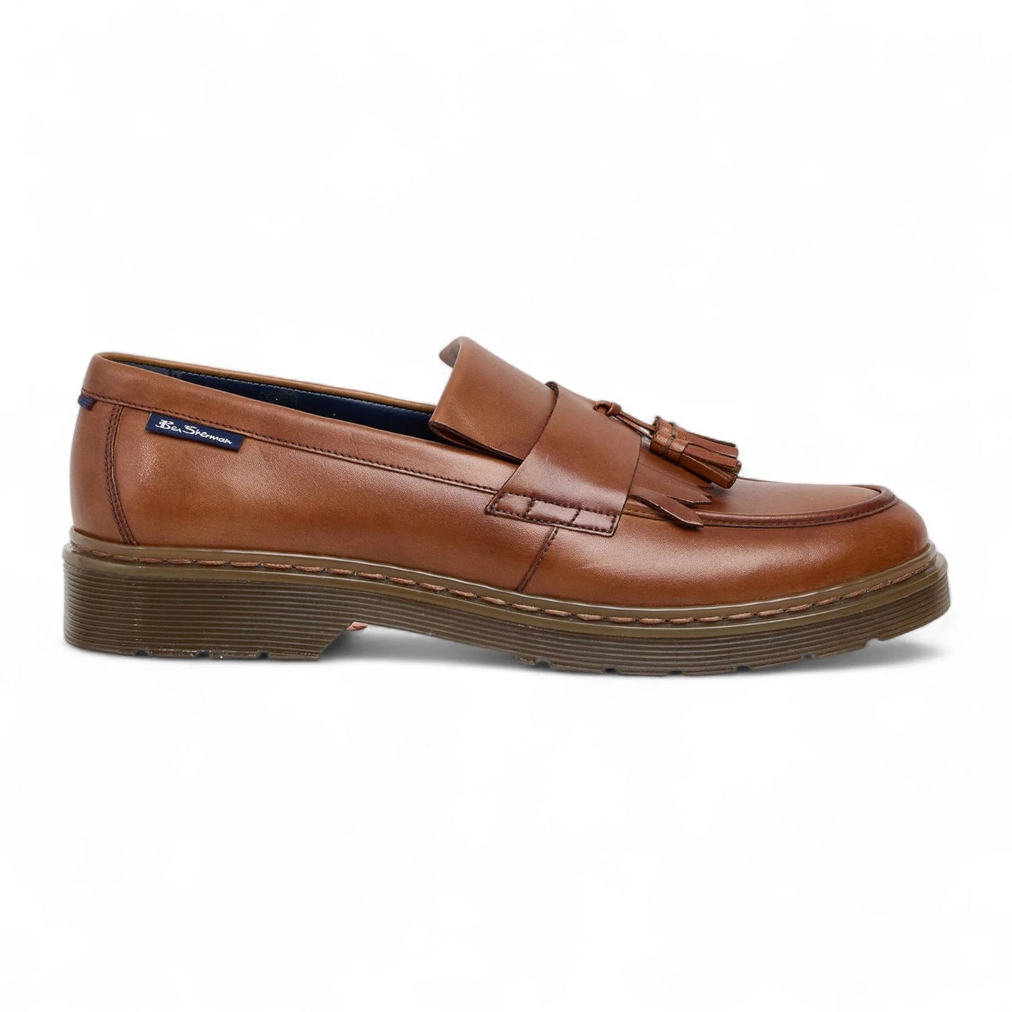 Zapatos mocasines de hombre de cuero marrón claro con suela gruesa y borlas.