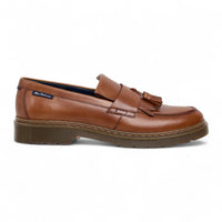 Zapatos mocasines de hombre de cuero marrón claro con suela gruesa y borlas.