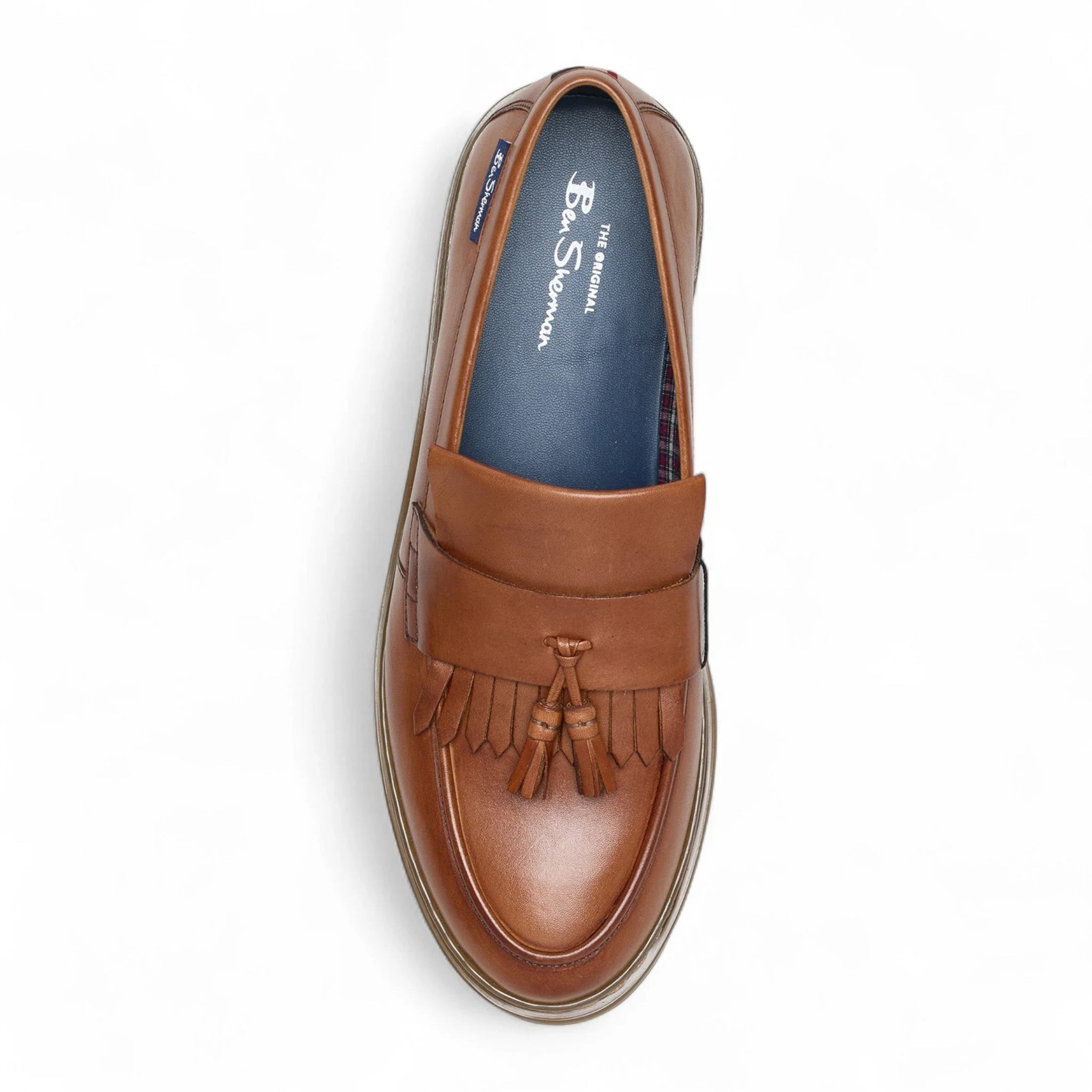 Zapatos mocasines de hombre de cuero marrón claro con suela gruesa y borlas.