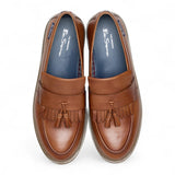 Zapatos mocasines de hombre de cuero marrón claro con suela gruesa y borlas.
