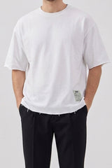 Camiseta blanca de hombre de corte relajado con borde sin rematar, mezcla de algodón y cuello redondo.