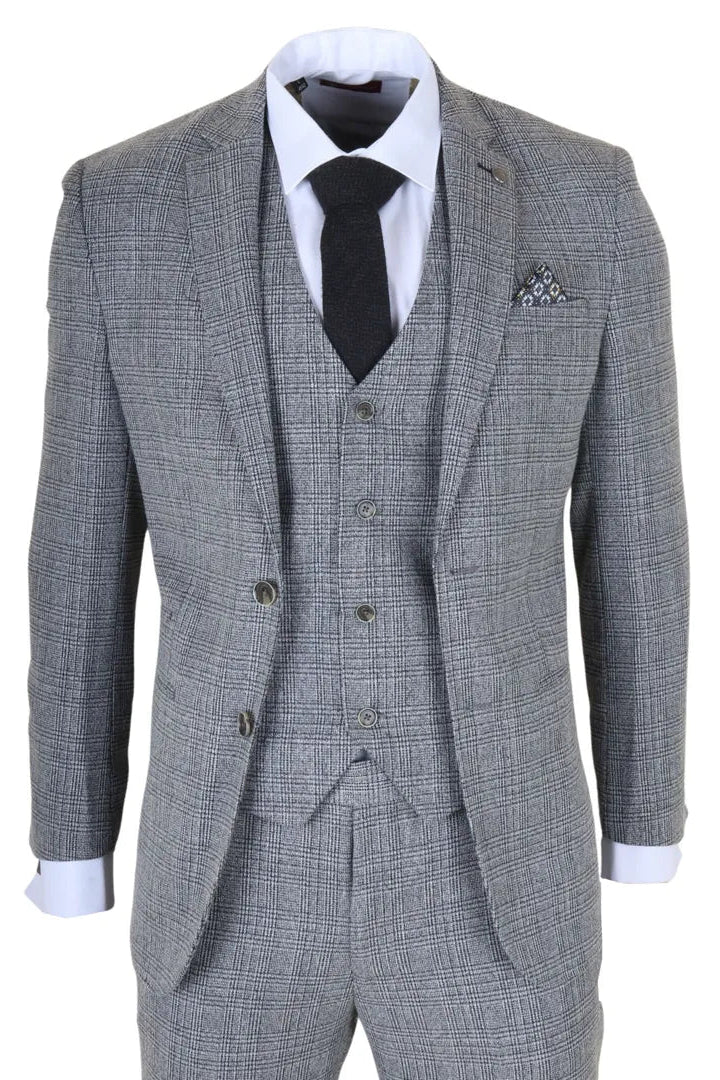 Traje gris a cuadros con camisa blanca, corbata negra y pañuelo de bolsillo sobre fondo blanco.