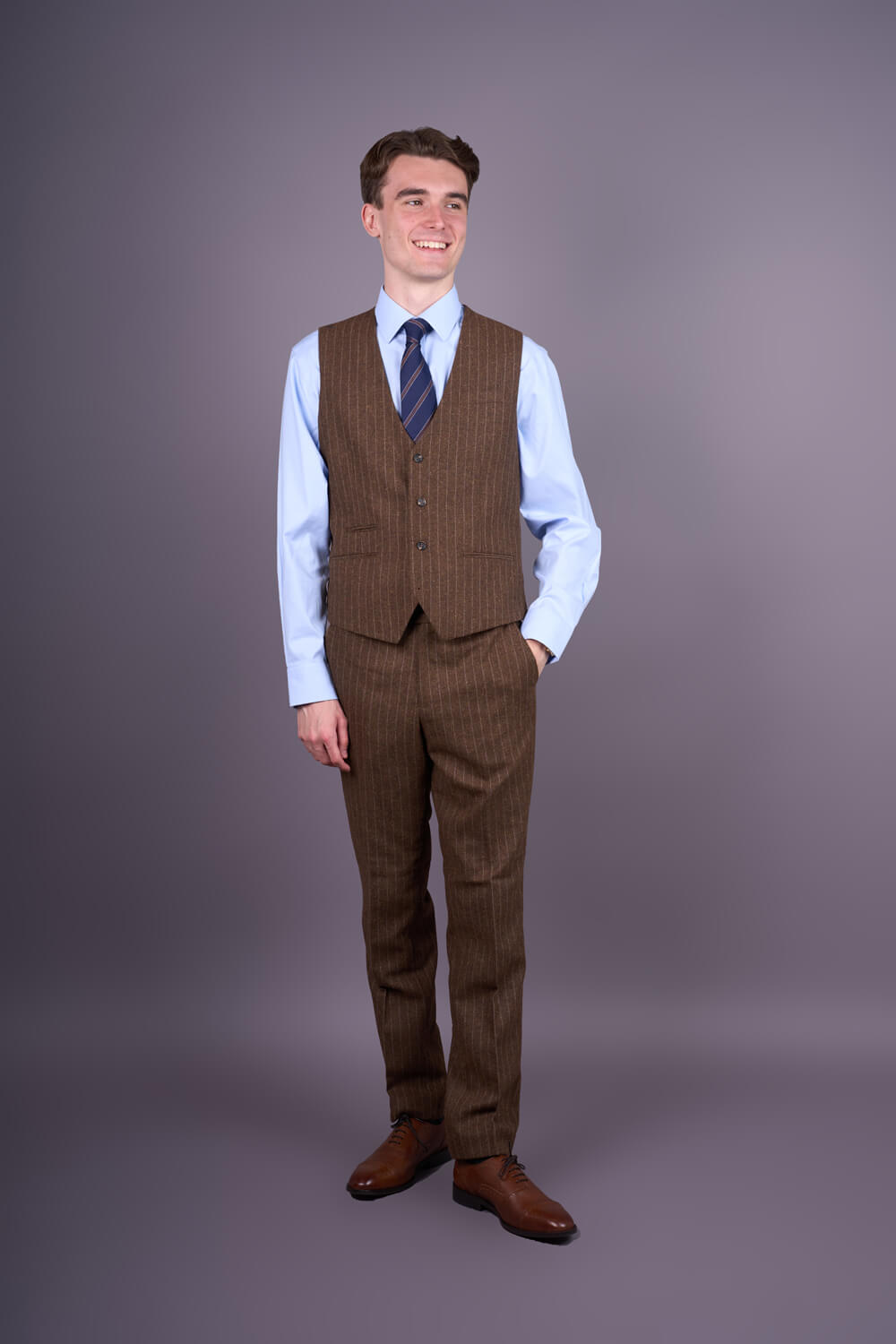 Traje de tres piezas para hombre, de corte ajustado y rayas finas marrones.
